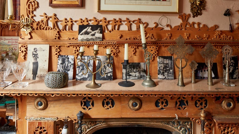 Candles and picture postcards on a mantlepiece with decorative fretwork at 575 Wandsworth Road, London